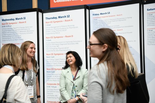 women talking in front of a poster