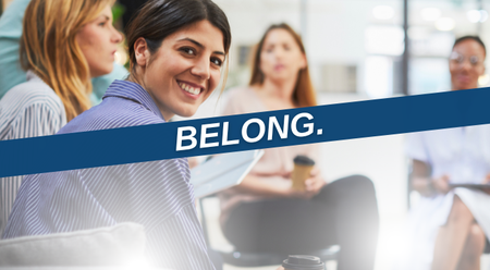 An image of people at a meeting with a purple banner that says "Belong."