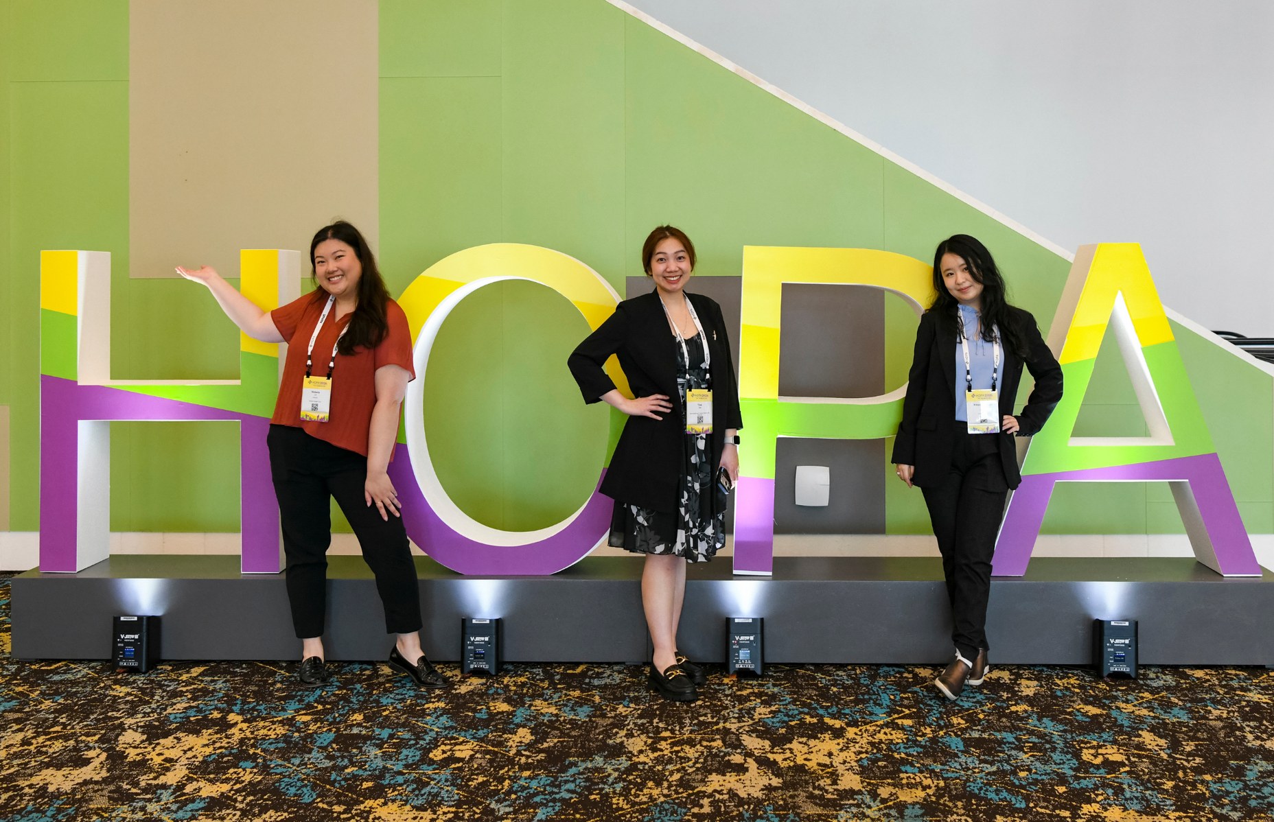 HOPA members standing by the HOPA signage