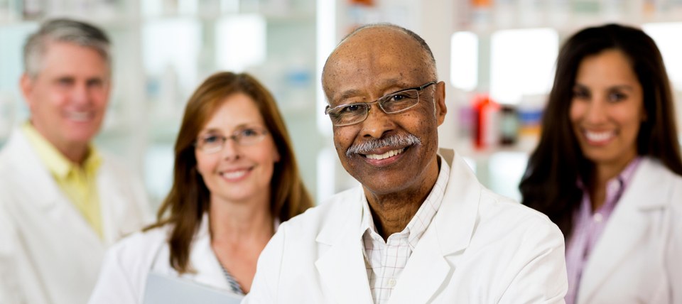 Four pharmacists standing in white coats