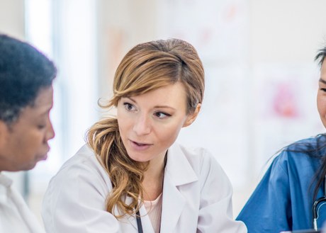 A group of doctors and pharmacists and nurses talking