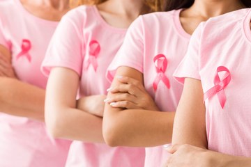 A line of women with breast cancer ribbons on their chests