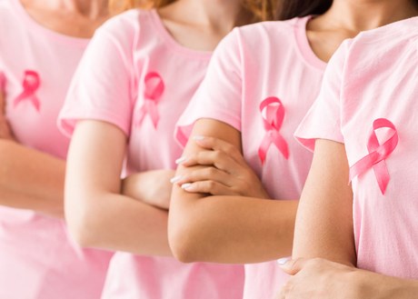 A line of women with breast cancer ribbons on their chests